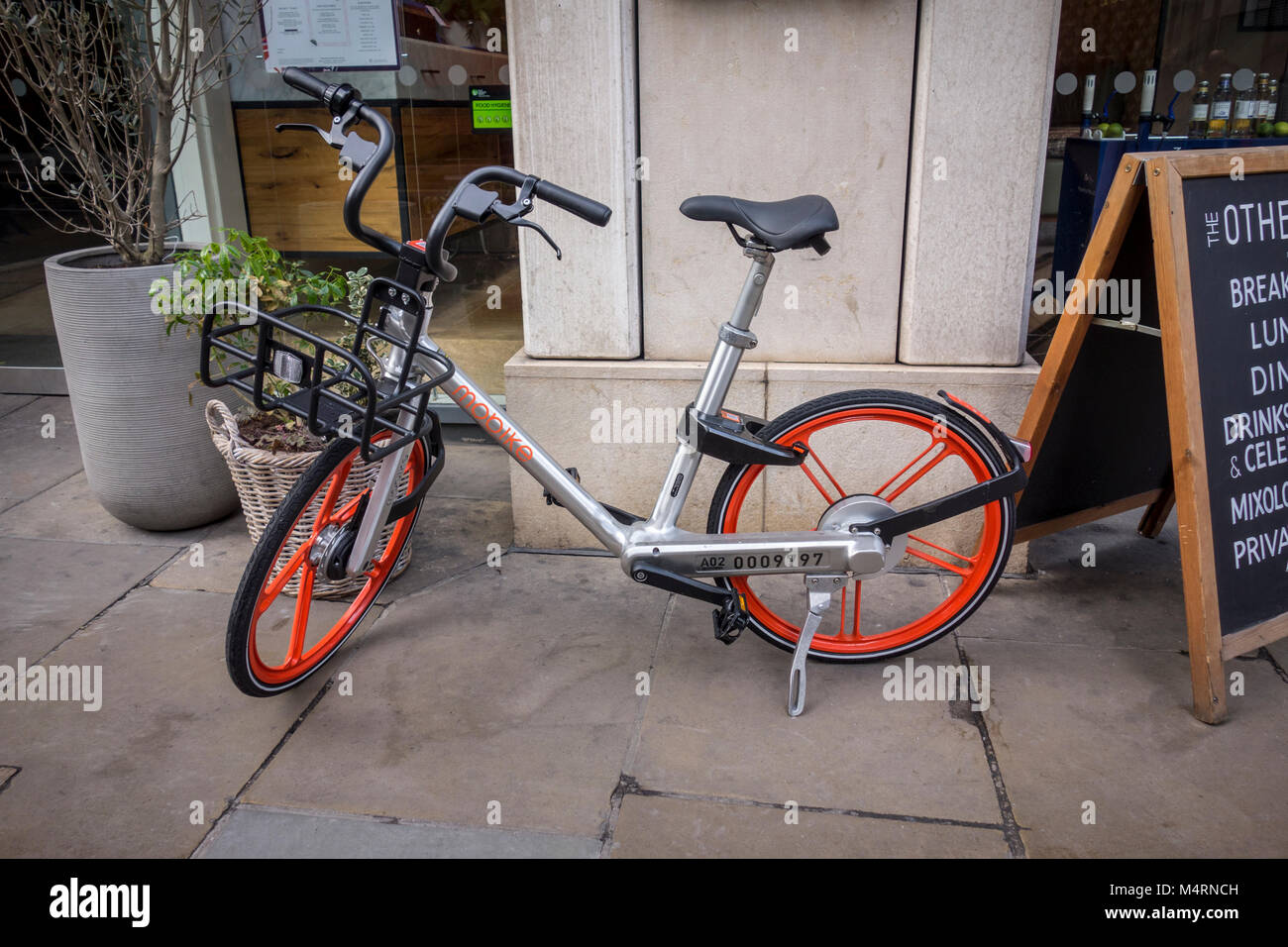 Mobike noleggio bici / noleggio biciclette parcheggiate fuori un bar ristorante a Londra, Regno Unito Foto Stock