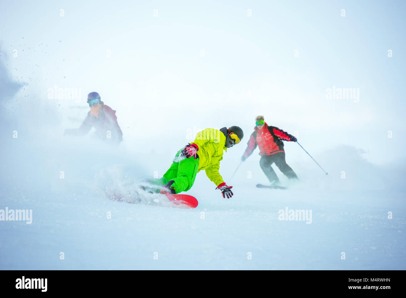 Sci di discesa con il concetto di gruppo di snowboarder Foto Stock
