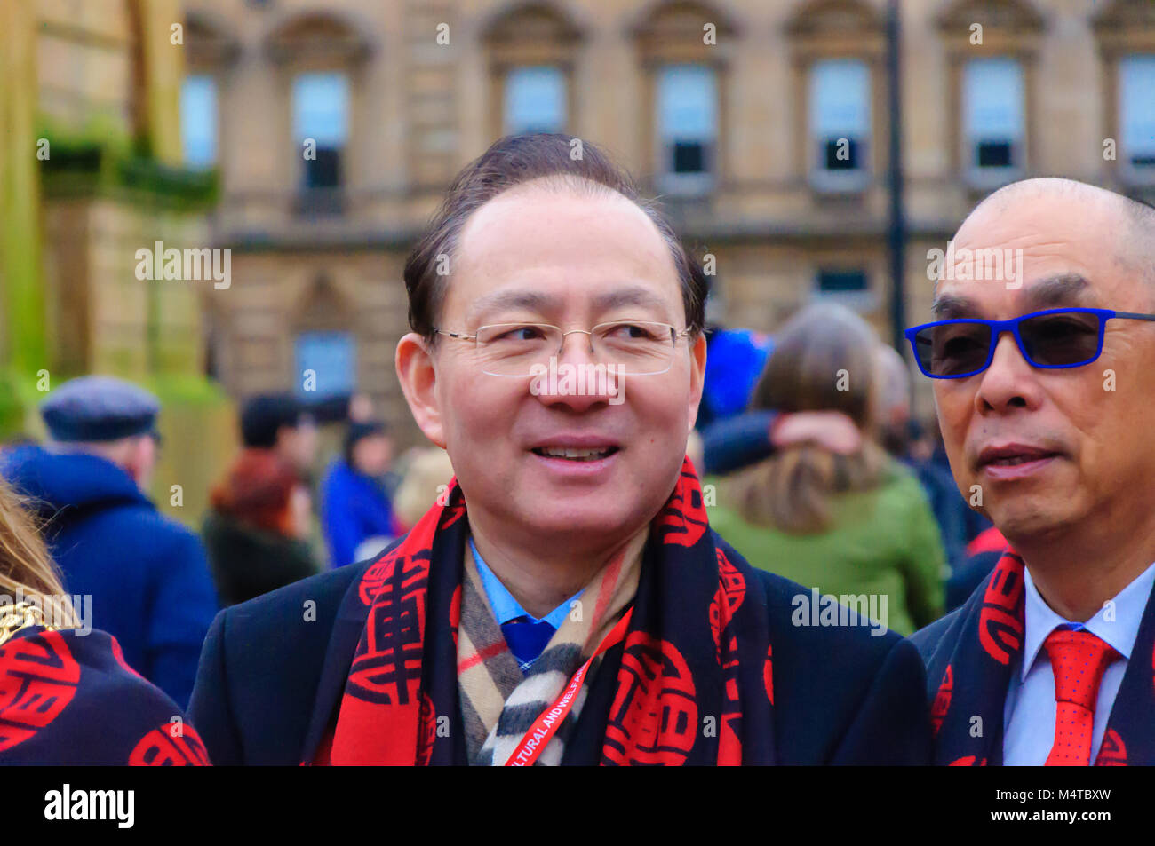 Glasgow, Scotland, Regno Unito. 18 Febbraio, 2018. Il cinese Console Generale Pan Xinchun festeggia il nuovo anno cinese 2018. Per contrassegnare l'anno del cane una celebrazione multiculturale si è tenuto a George Square che includevano il drago e il leone danze, musica da Glasgow Police Pipe Band e percussionisti africani. La manifestazione è stata organizzata dalla cultura cinese e la società del benessere in Scozia in partenariato con il consiglio della città. Alla manifestazione hanno partecipato il Lord Provost Bolander Eva. Credito: Berretto Alamy/Live News Foto Stock