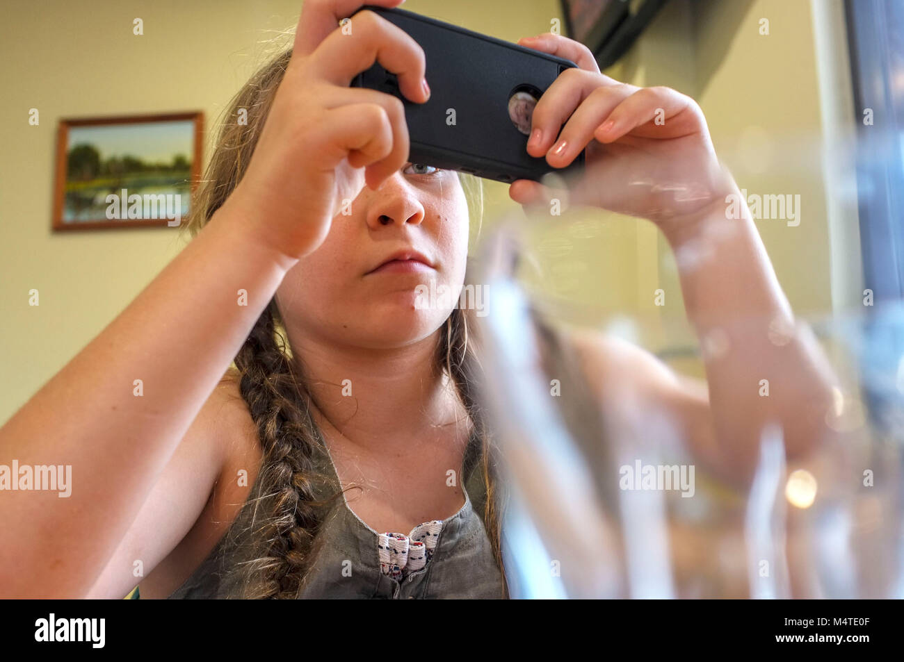 Pre-teen ragazza che gioca con un telefono cellulare. Foto Stock
