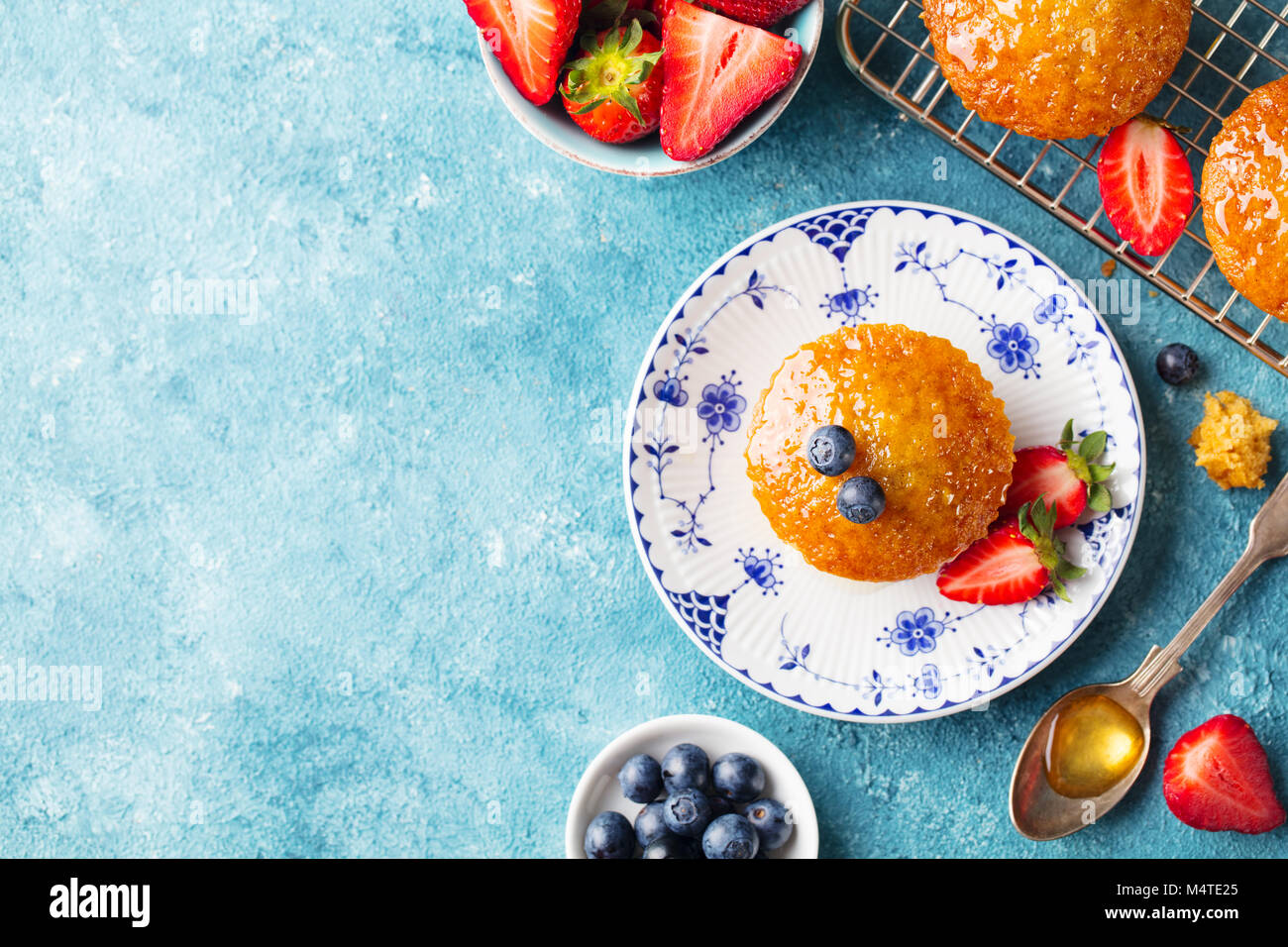 Muffin, tortina con frutti di bosco freschi su una piastra. Sfondo blu. Vista dall'alto. Copia dello spazio. Foto Stock