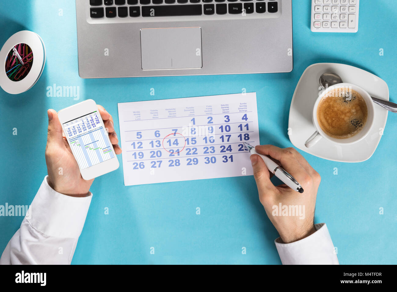 Imprenditore marcatura calendario sul calendario con diagramma di Gantt sulla schermata dello smartphone al lavoro Foto Stock