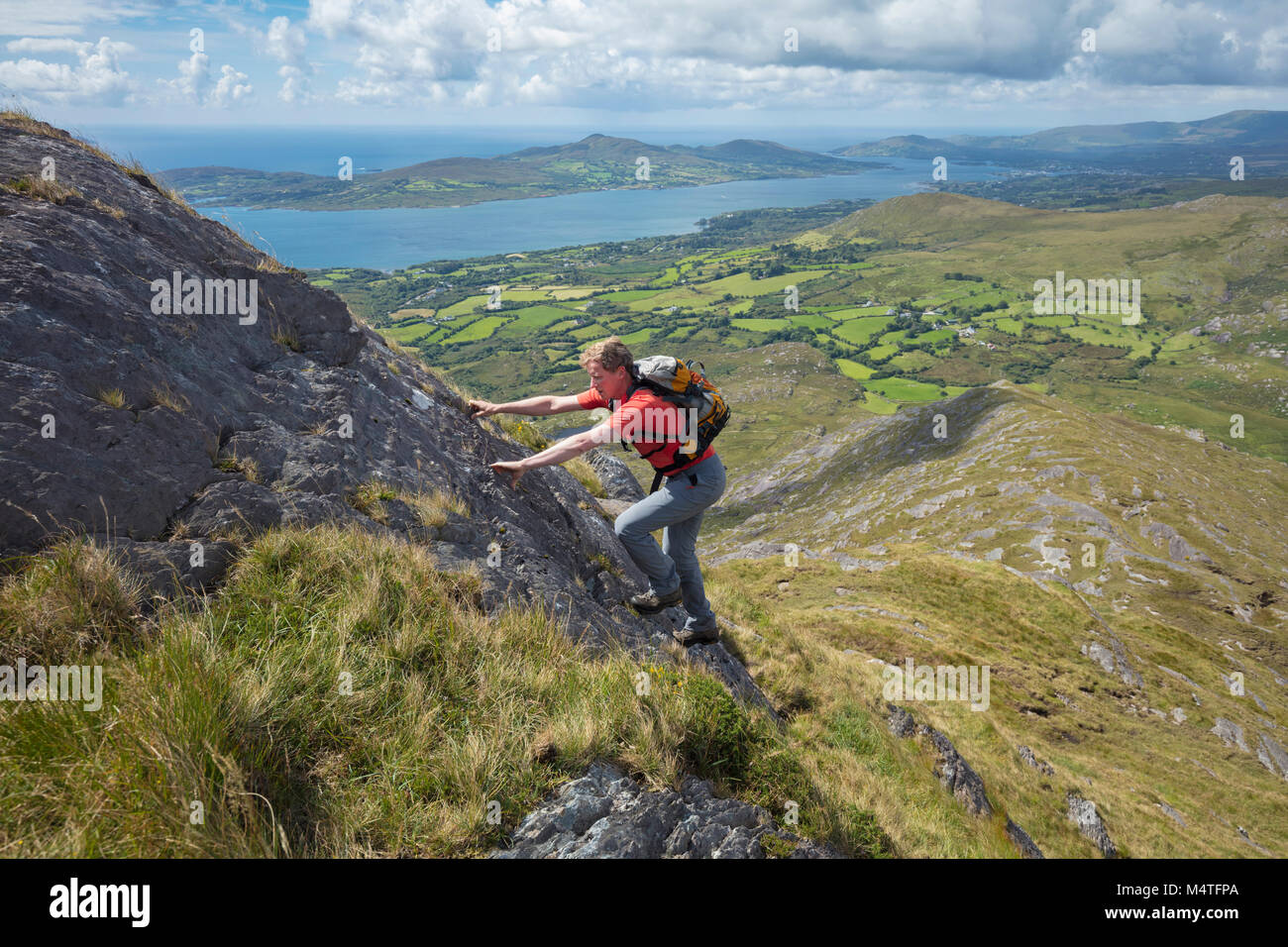 Scrambling degli escursionisti sulla cresta sud-ovest della collina di affamati, penisola di Beara, County Cork, Irlanda. Foto Stock