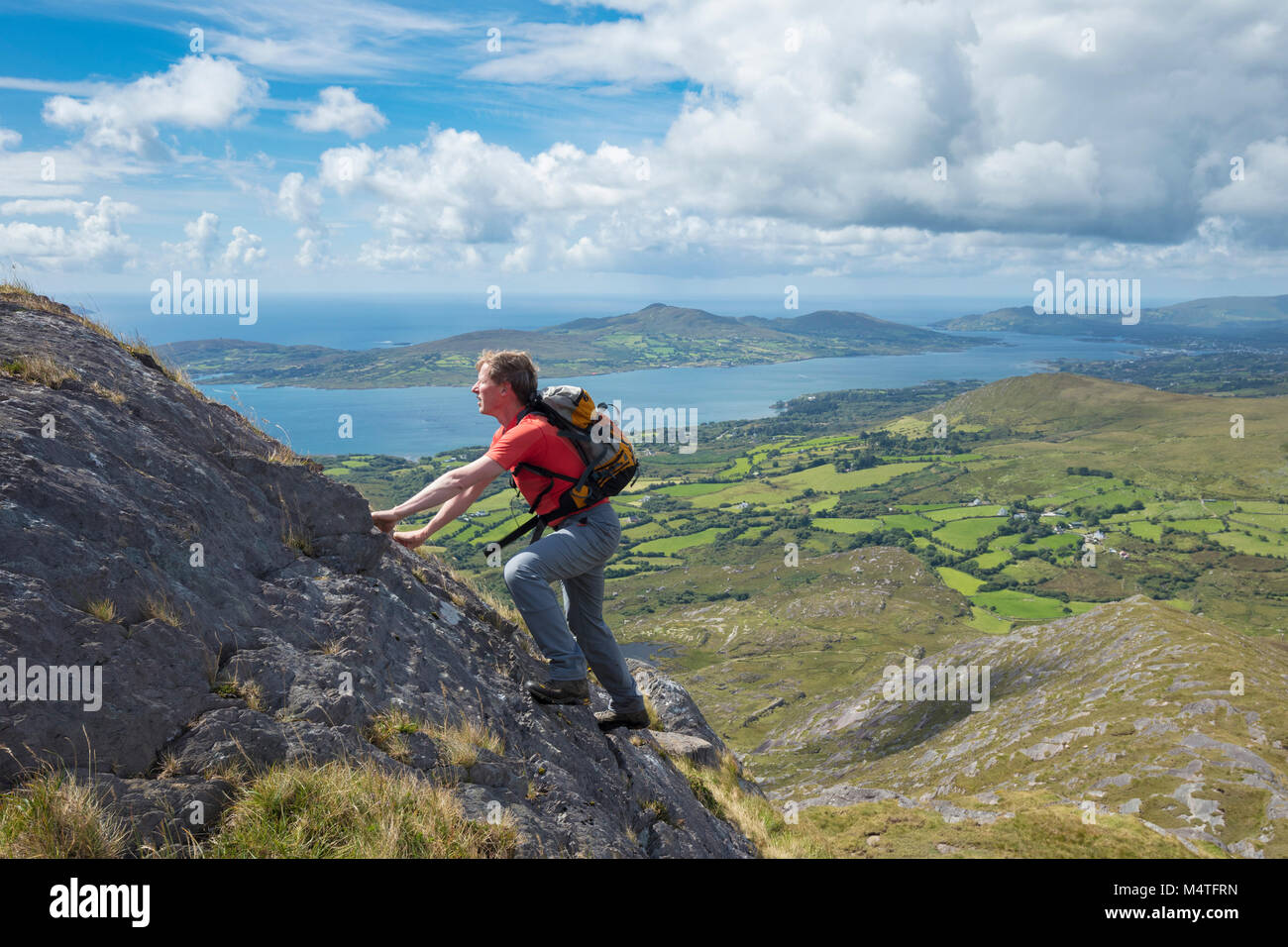 Scrambling degli escursionisti sulla cresta sud-ovest della collina di affamati, penisola di Beara, County Cork, Irlanda. Foto Stock