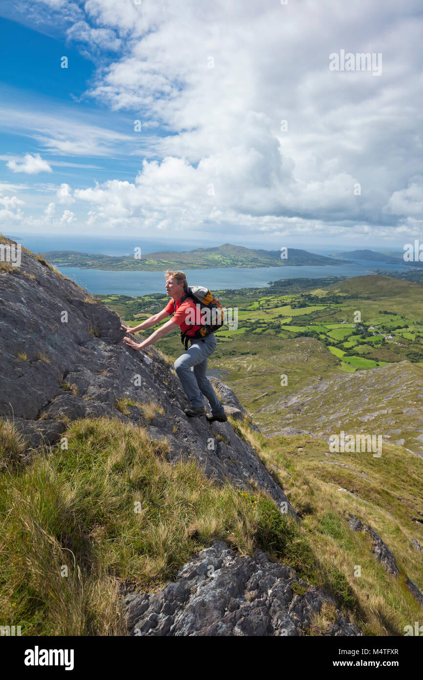 Scrambling degli escursionisti sulla cresta sud-ovest della collina di affamati, penisola di Beara, County Cork, Irlanda. Foto Stock