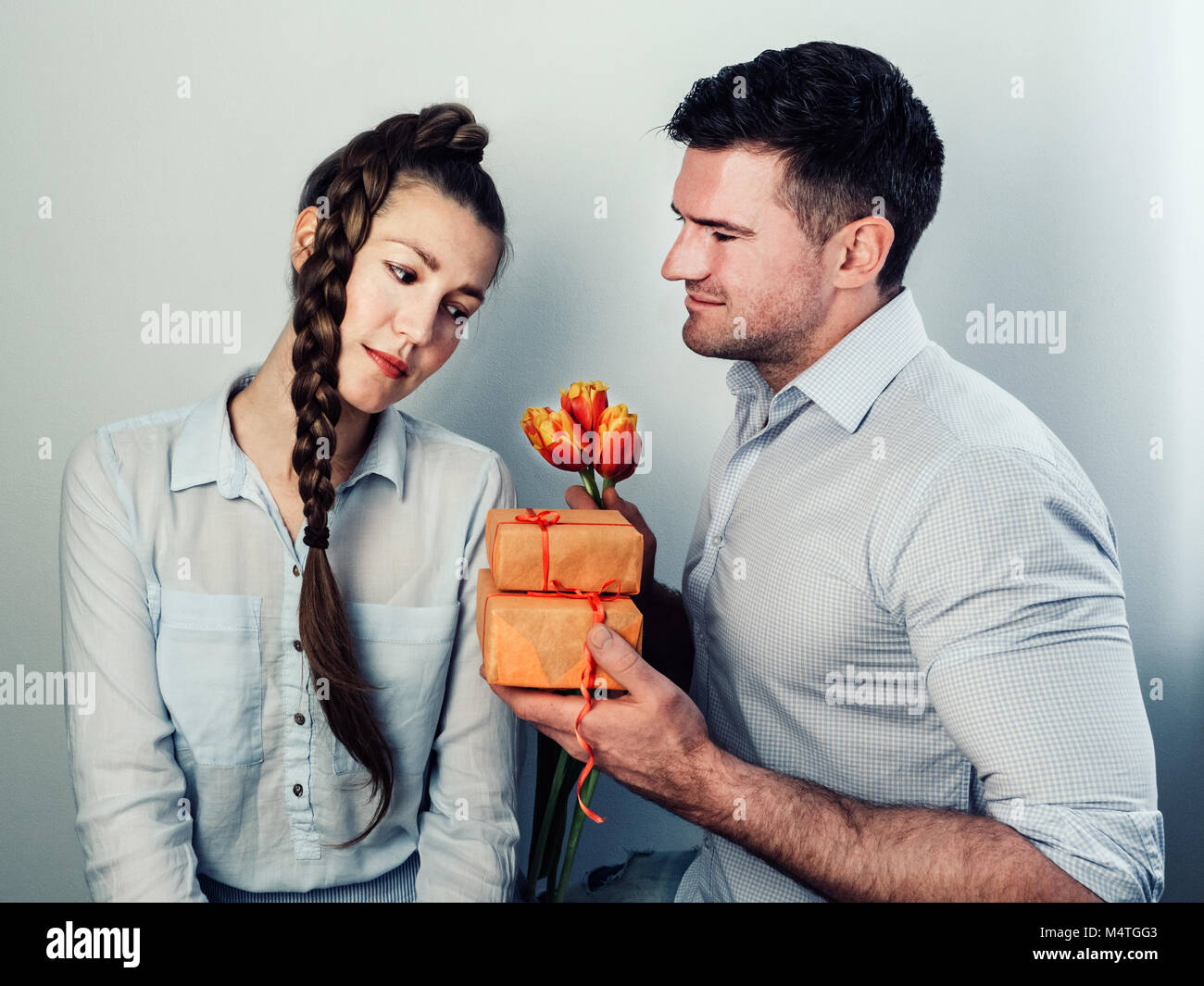 Uomo bello dare un regalo e fiori alla donna amata Foto stock - Alamy
