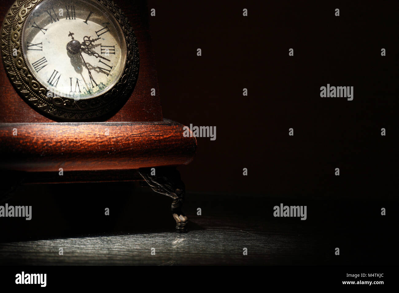 Vintage orologio da tavolo su sfondo scuro con spazio libero Foto Stock