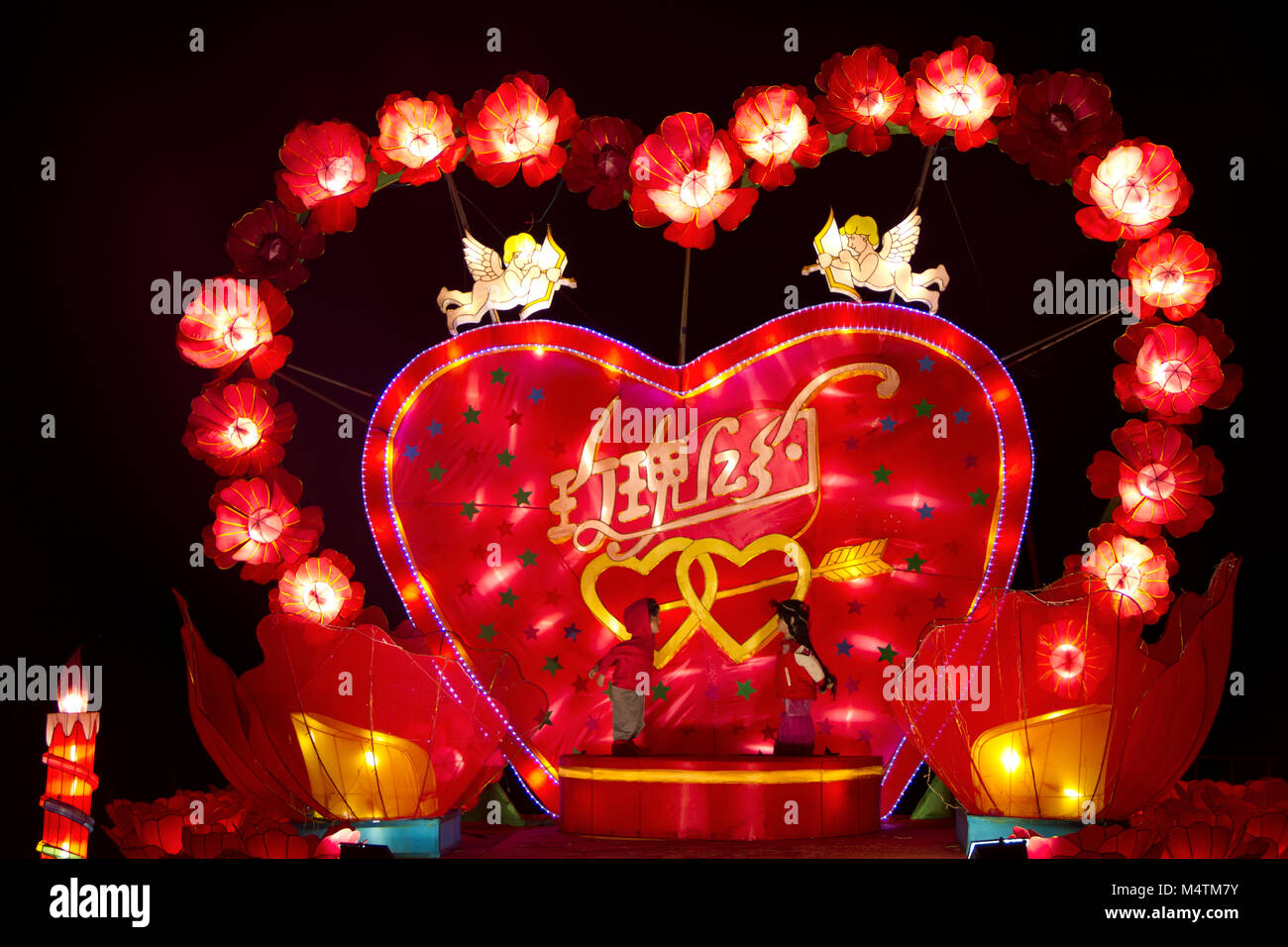 Haren, Paesi Bassi - 22 Novembre 2011: Close up della vibrante cuore rosso circondati da fiori, putti e un maschio e femmina bambola kissing, Cinese l Foto Stock