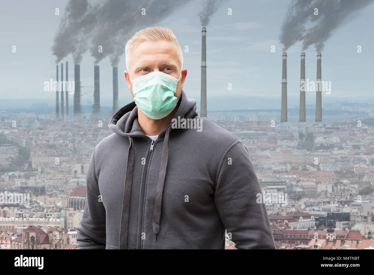 Close-up di un uomo che indossa la maschera di bocca contro l emissione di fumi da ciminiere Foto Stock