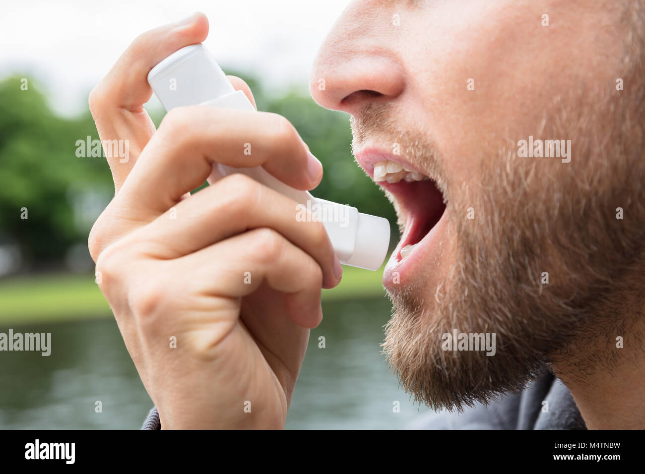 Close-up di barba uomo con asma Inalatore per essere sano Foto Stock