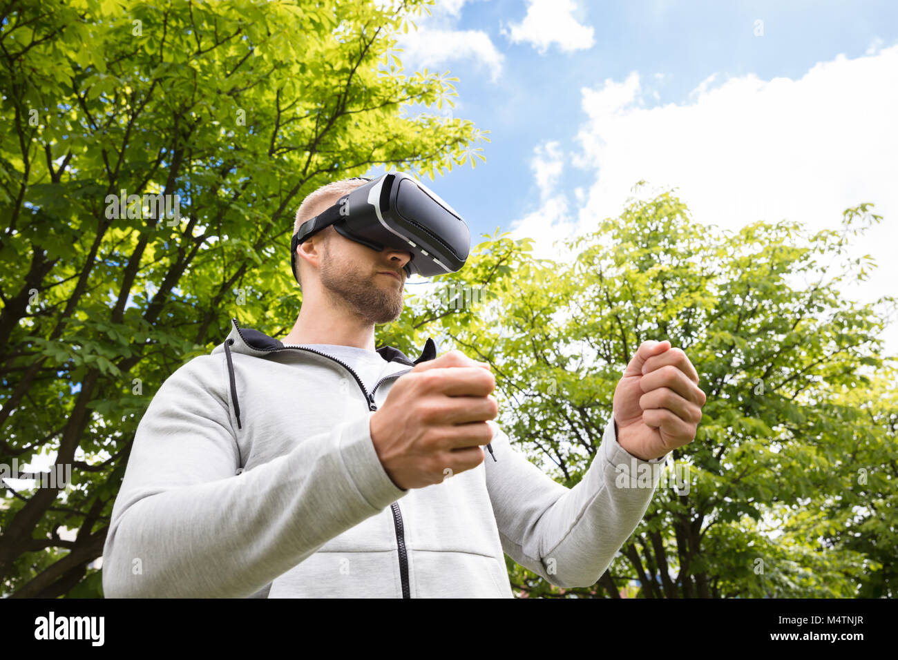 Attraente Uomo Barbuto godendo di occhiali per realtà virtuale in posizione di parcheggio Foto Stock