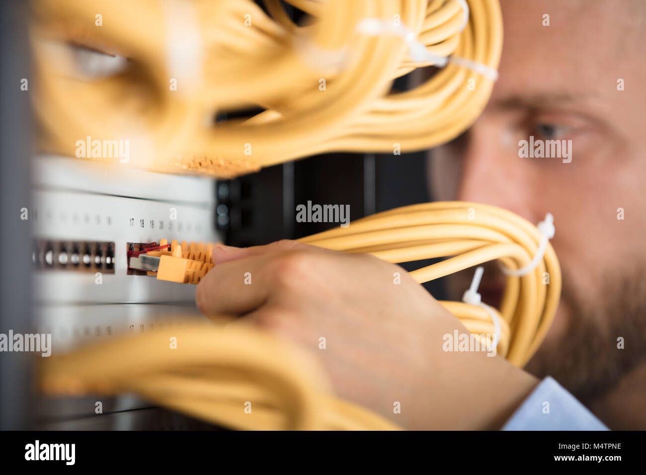 Close-up di ingegnere collegando i cavi nel Server nel centro dati Foto Stock