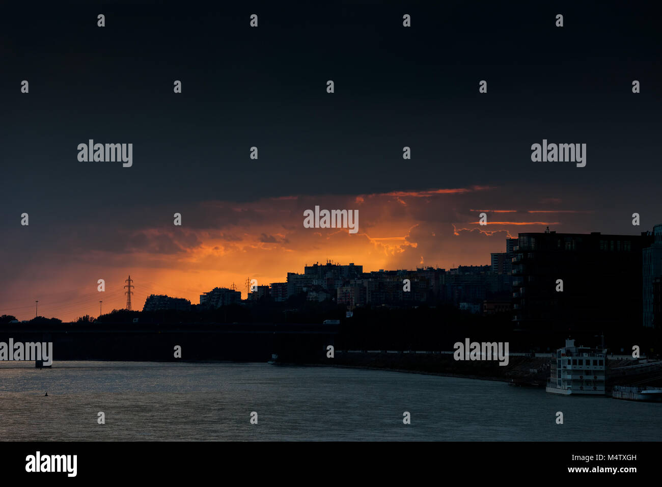Dark Cloud tempesta al tramonto sopra la città di Bratislava e il Danubio in Slovacchia, Europa Foto Stock