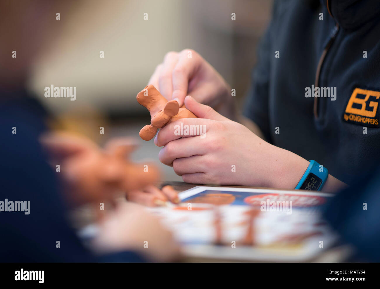 Un bambino facendo un modello di plastilina utilizzando argilla plastilina durante un laboratorio artigianale. Foto Stock