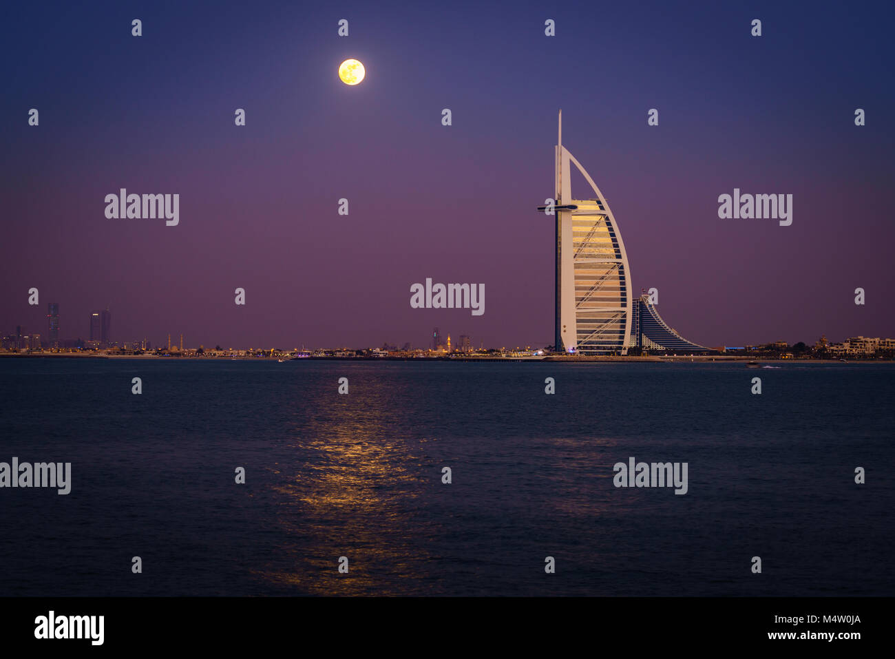 Dubai, UAE, Dicembre 13, 2016: la luna piena è in aumento su Burj Al Arab - il mondo solo 7 stelle lusso Foto Stock