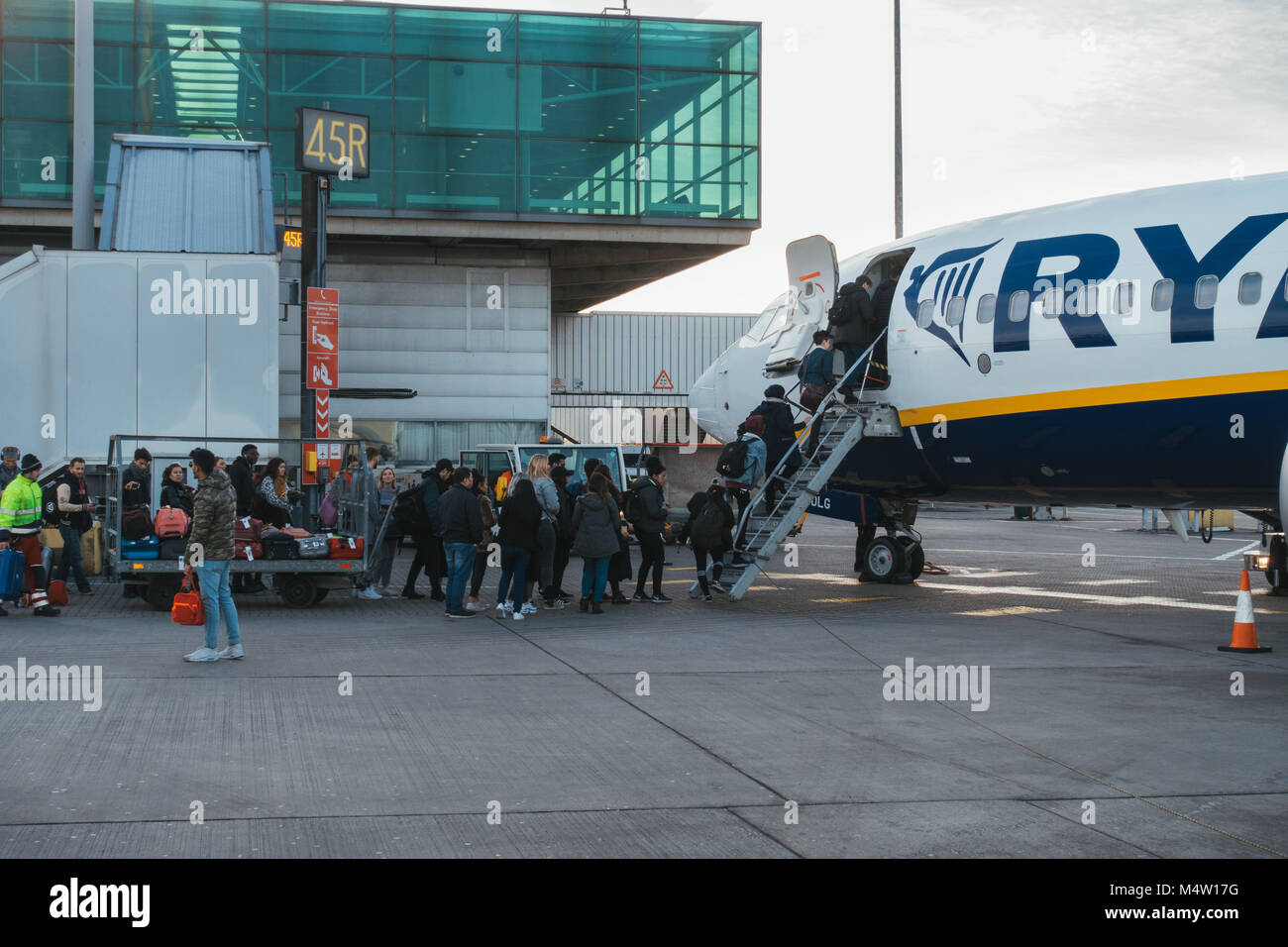 I passeggeri di salire a bordo di un jet di Ryanair dopo la loro nuova cabina politica sacchetto è entrato in vigore - chiedendo loro di rinunciare al loro bagaglio di equipaggi di caricamento Foto Stock