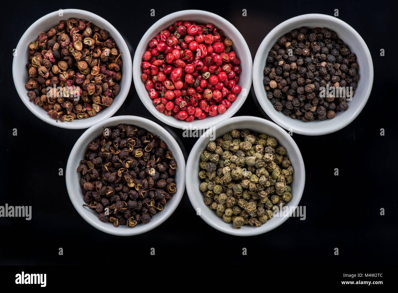 Cinque diversi semi di pepe in vasi, spezie orientali, mix Foto Stock