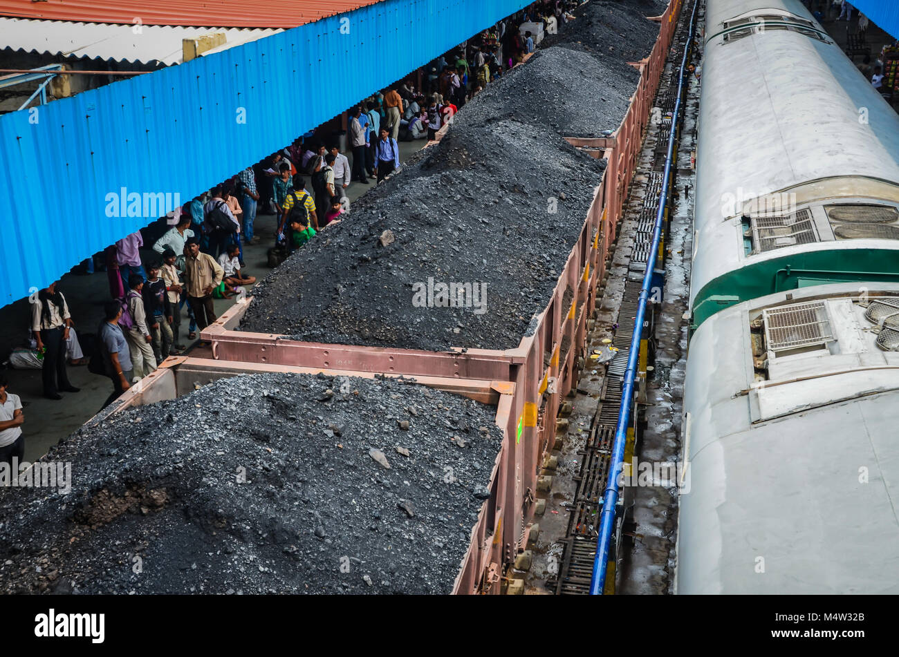 Il carbone in attesa del treno alla stazione in India. Foto Stock