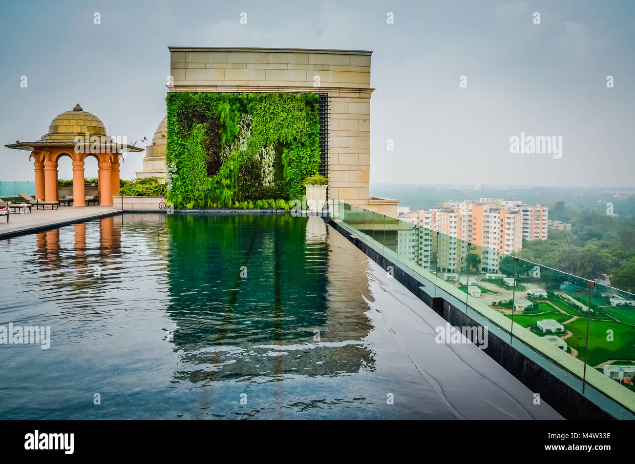 Svuotare infinity pool sul tetto a terrazza che si affaccia su New Delhi, India. In vetro trasparente di scherma piscina protegge dal bordo del tetto alto sopra di New Delhi, India city Foto Stock