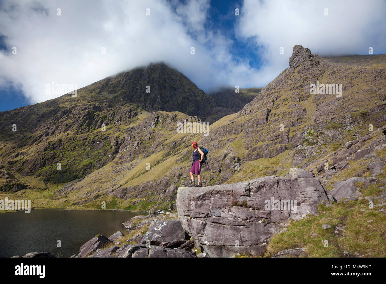Escursionista e Lough Gouragh sotto Carrauntoohil, il MacGillycuddy Reeks, nella contea di Kerry, Irlanda. Foto Stock