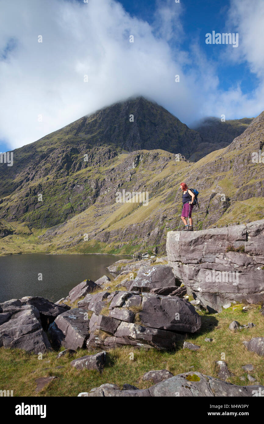 Escursionista e Lough Gouragh sotto Carrauntoohil, il MacGillycuddy Reeks, nella contea di Kerry, Irlanda. Foto Stock