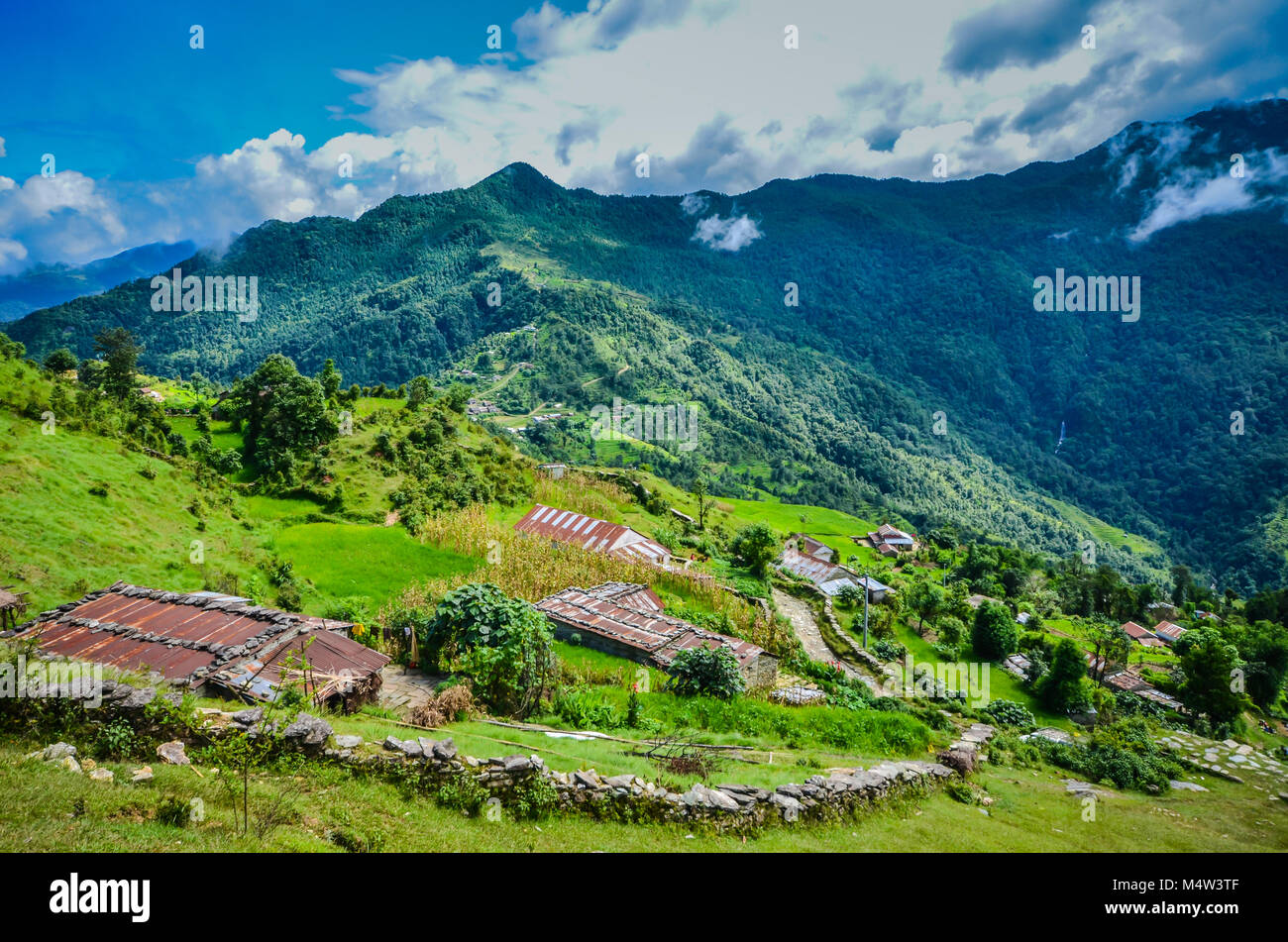 Villaggio rurale e fattoria sull Annapurna trailside pendenza in montagna himalayana. Foto Stock