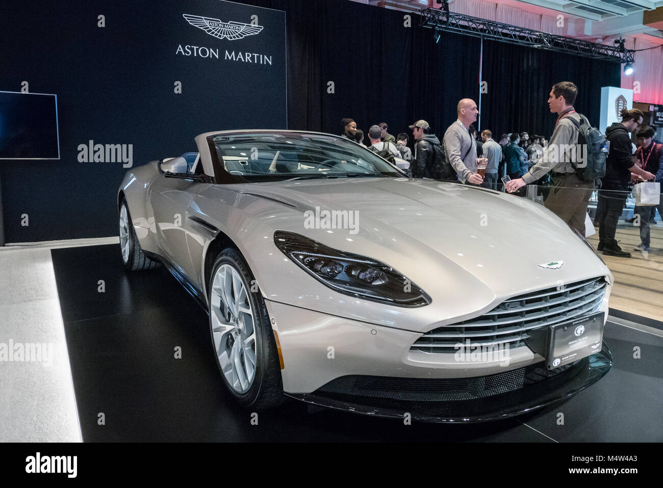Aston Martin con persone in chat in background Foto Stock