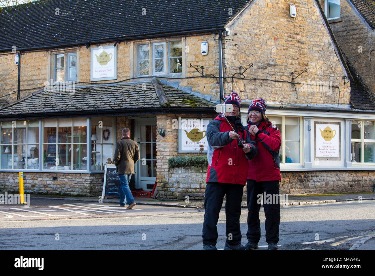 BOURTON SULL'ACQUA, Regno Unito - Febbraio 15th, 2018: turisti vengono scattate le foto in Bourton-on-the-acqua, che è un villaggio nel Gloucestershire trova Foto Stock