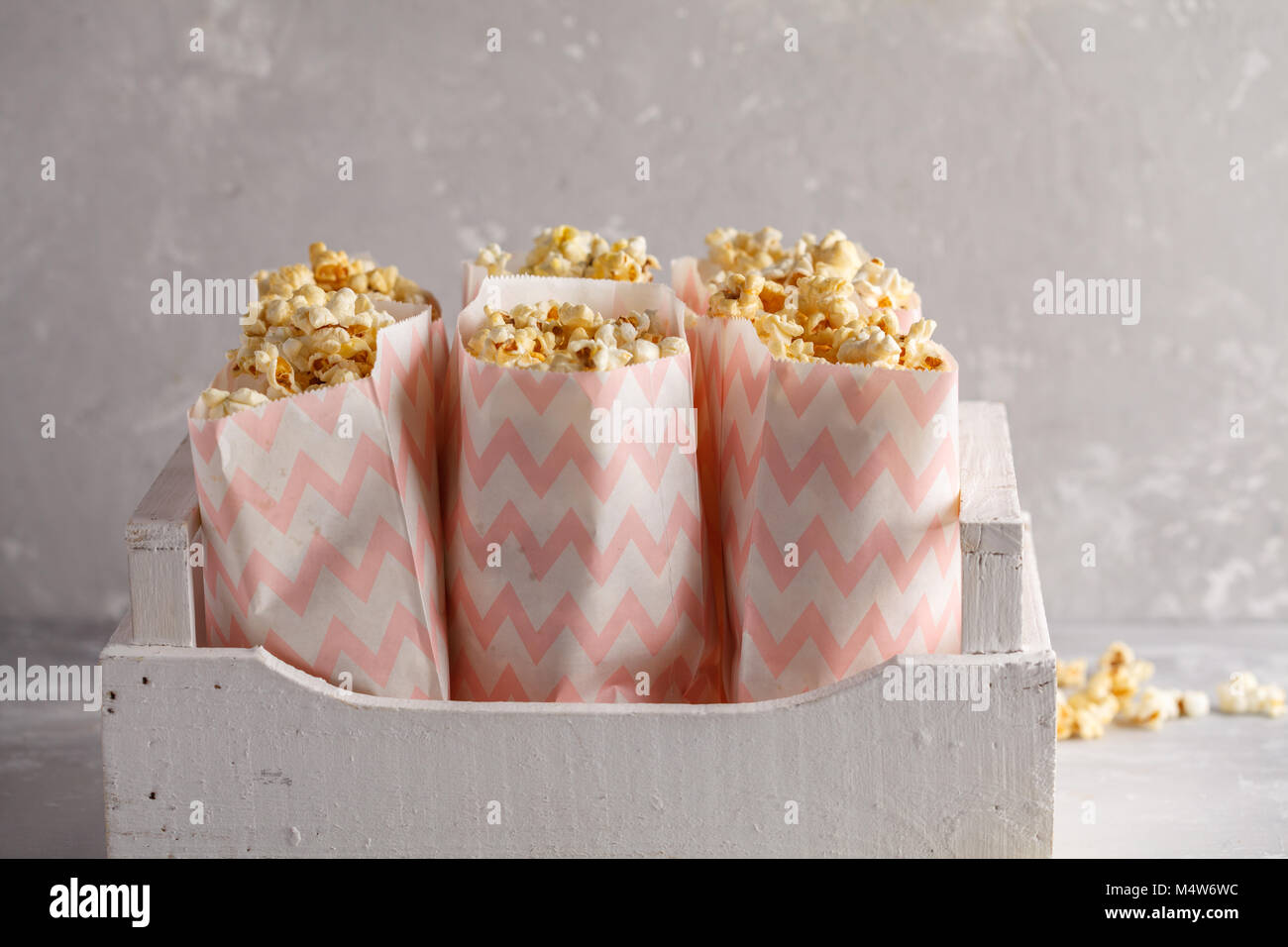 Golden caramello pop corn in sacchetti di carta in un bianco scatola di  legno Foto stock - Alamy