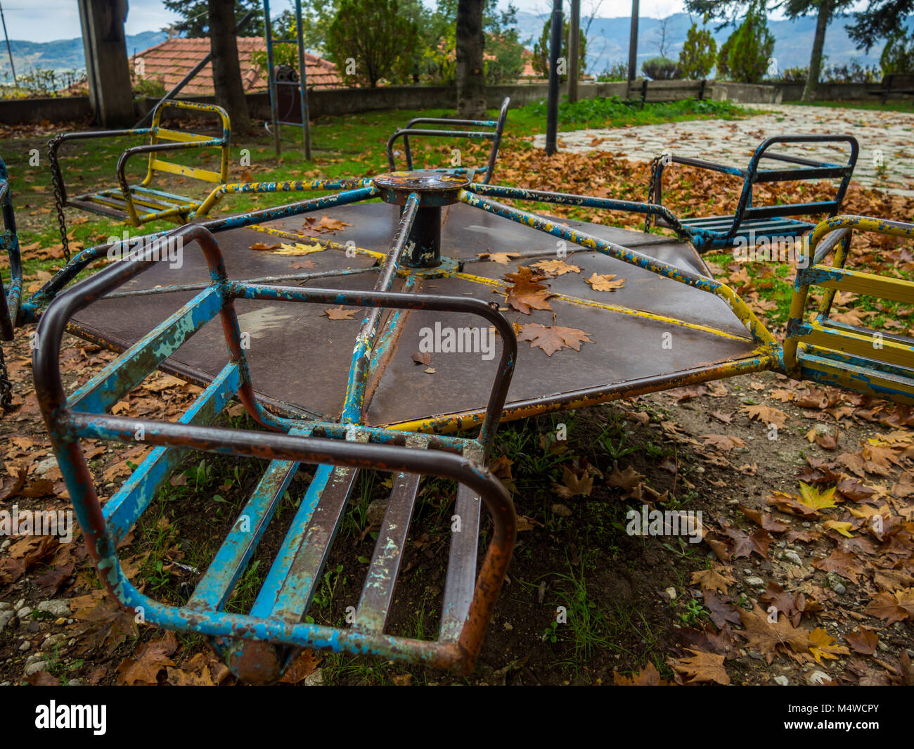 Colorato parco giochi arrugginito in autunno Foto Stock