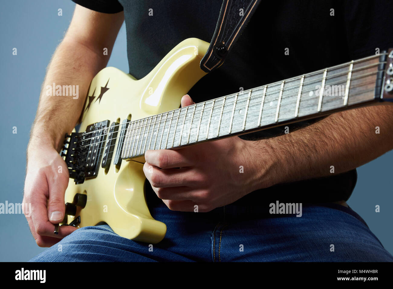 Le mani di un giovane uomo in possesso di una chitarra elettrica Foto Stock