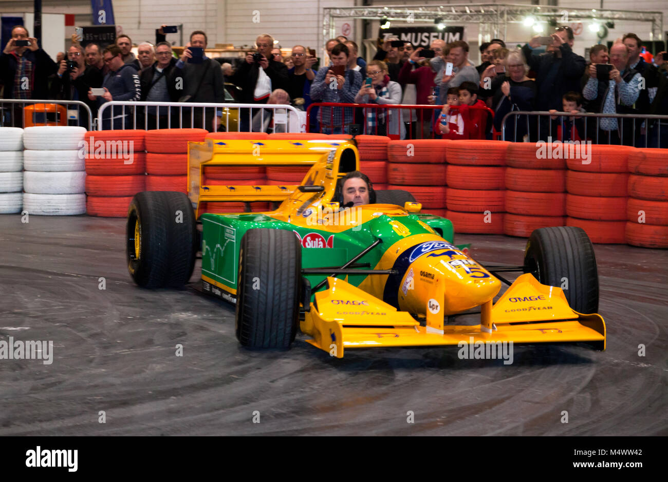 Nigel Mansell CBE, alla guida di Michael Schumacher la Benetton 1993 193B auto di Formula Uno giù il Grand Avenue duringh il 2018 London Classic Car Show Foto Stock