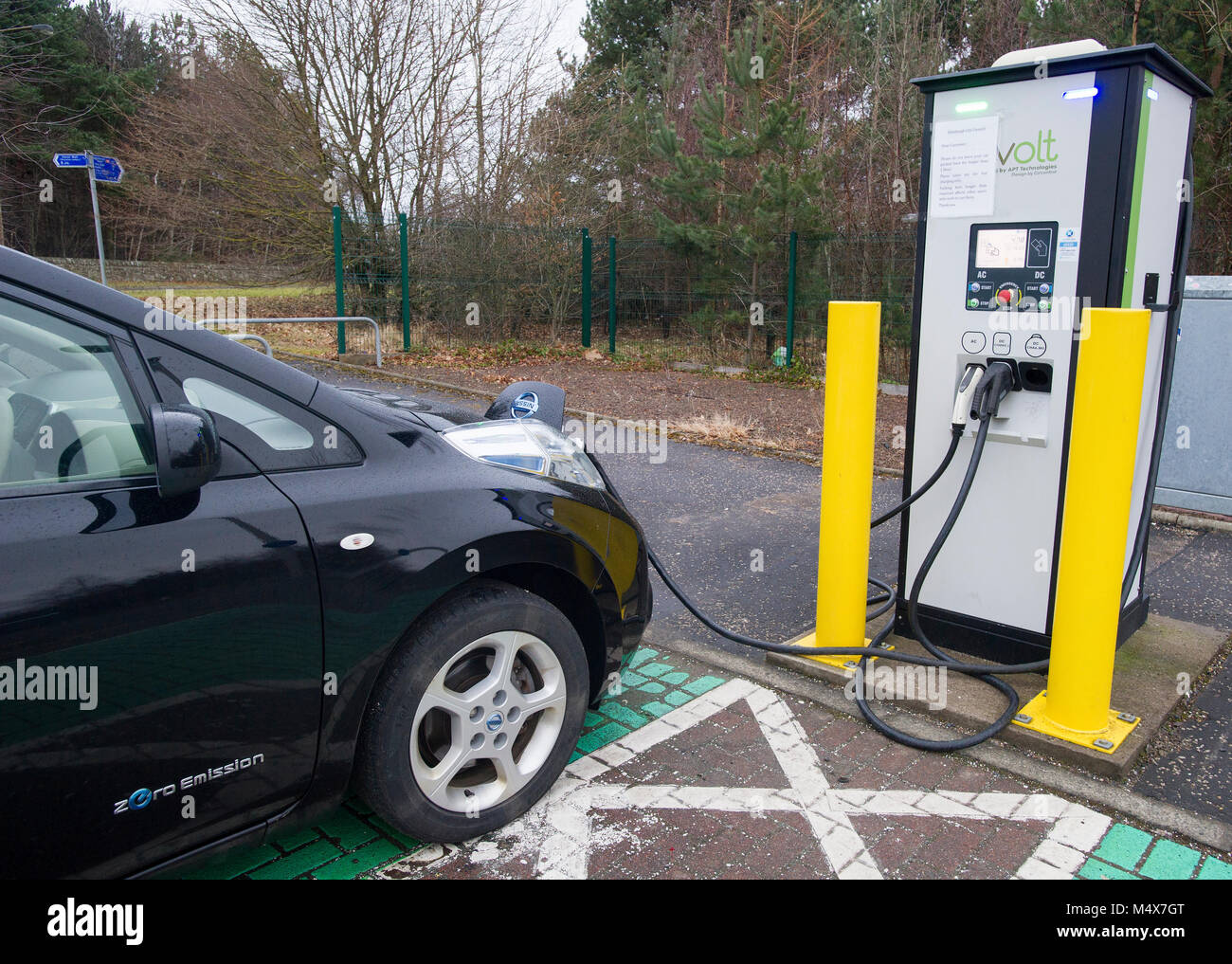Una Nissan Leaf auto elettrica utilizzando un tri-caricabatteria rapido a un veicolo elettrico stazione di carica, Riccarton, Edimburgo. Foto Stock