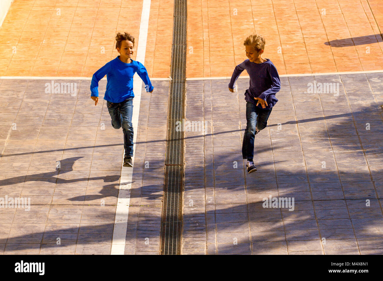 Contenti i bambini salti, corsa all'aperto al giorno di sole Foto Stock