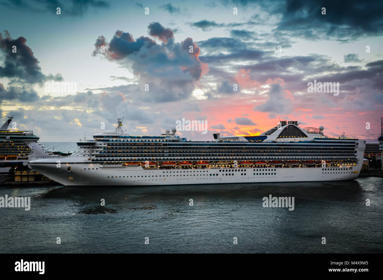 Magnifico tramonto arancione sullo sfondo dietro la nave di crociera nei Caraibi. Foto Stock