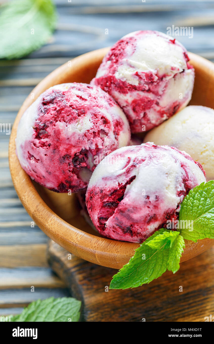Gelato alla vaniglia con uve secche di Corinto nella ciotola di legno. Foto Stock