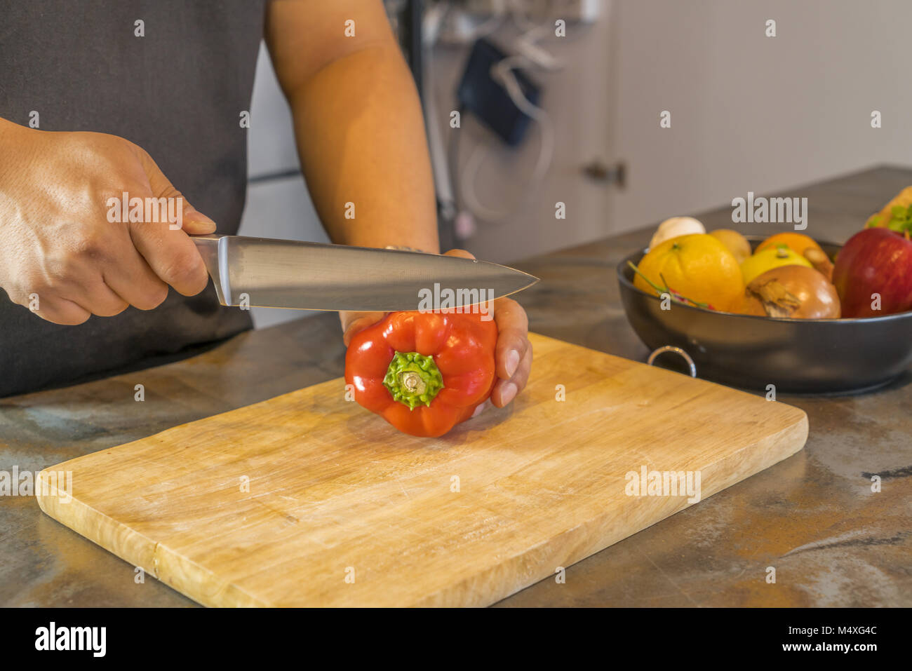 Lo Chef il taglio di peperone rosso su larga in legno Foto Stock