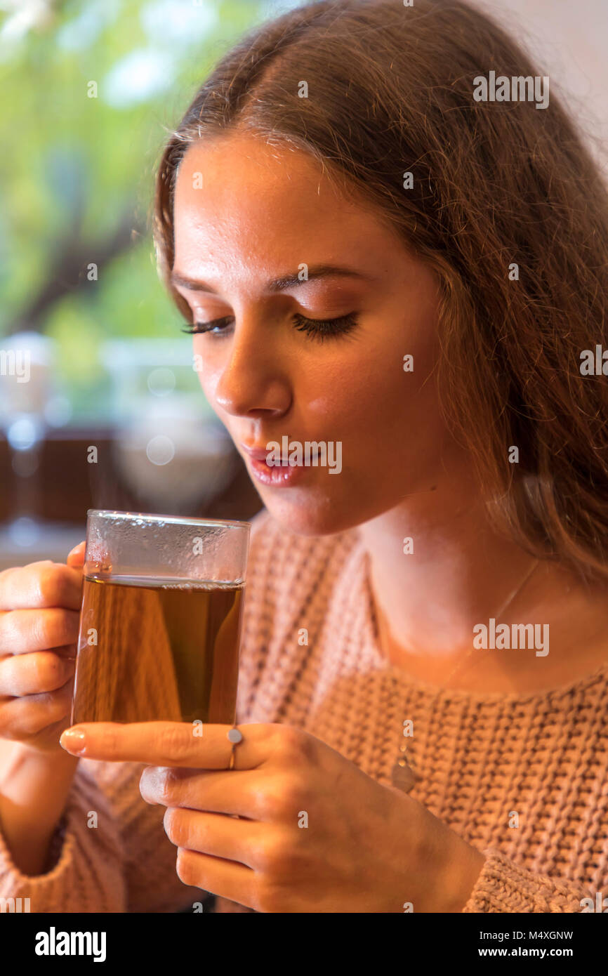 Giovane donna gode di una tazza di tè, Foto Stock