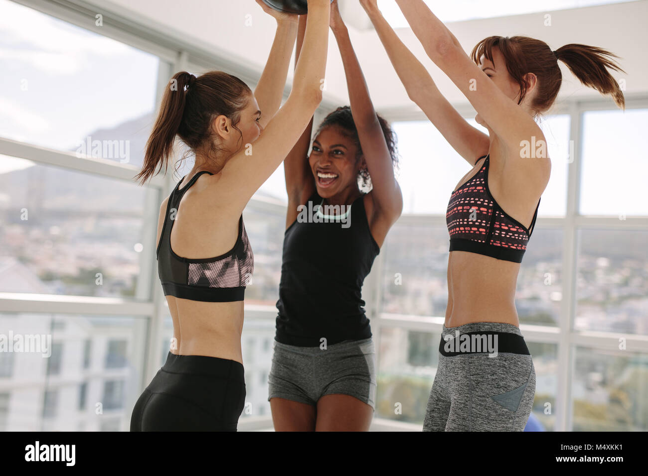 Donna sorridente divertendosi al fitness studio. Le ragazze in piedi e sorridente dopo aver eseguito correttamente la sessione di allenamento. Foto Stock