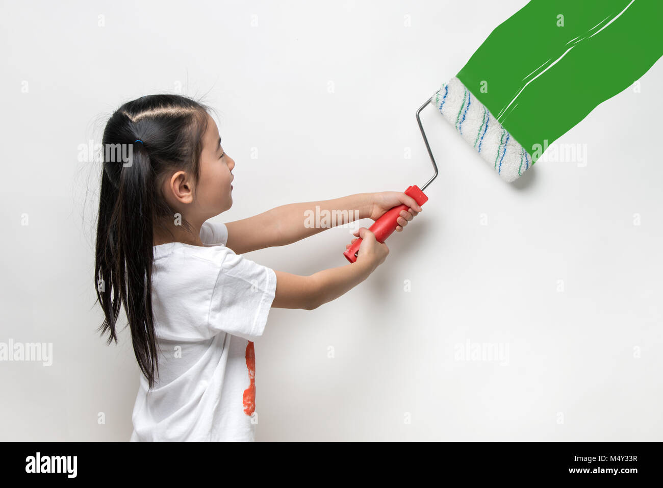 Carino ragazza asiatica di contenimento del rullo di vernice Foto Stock