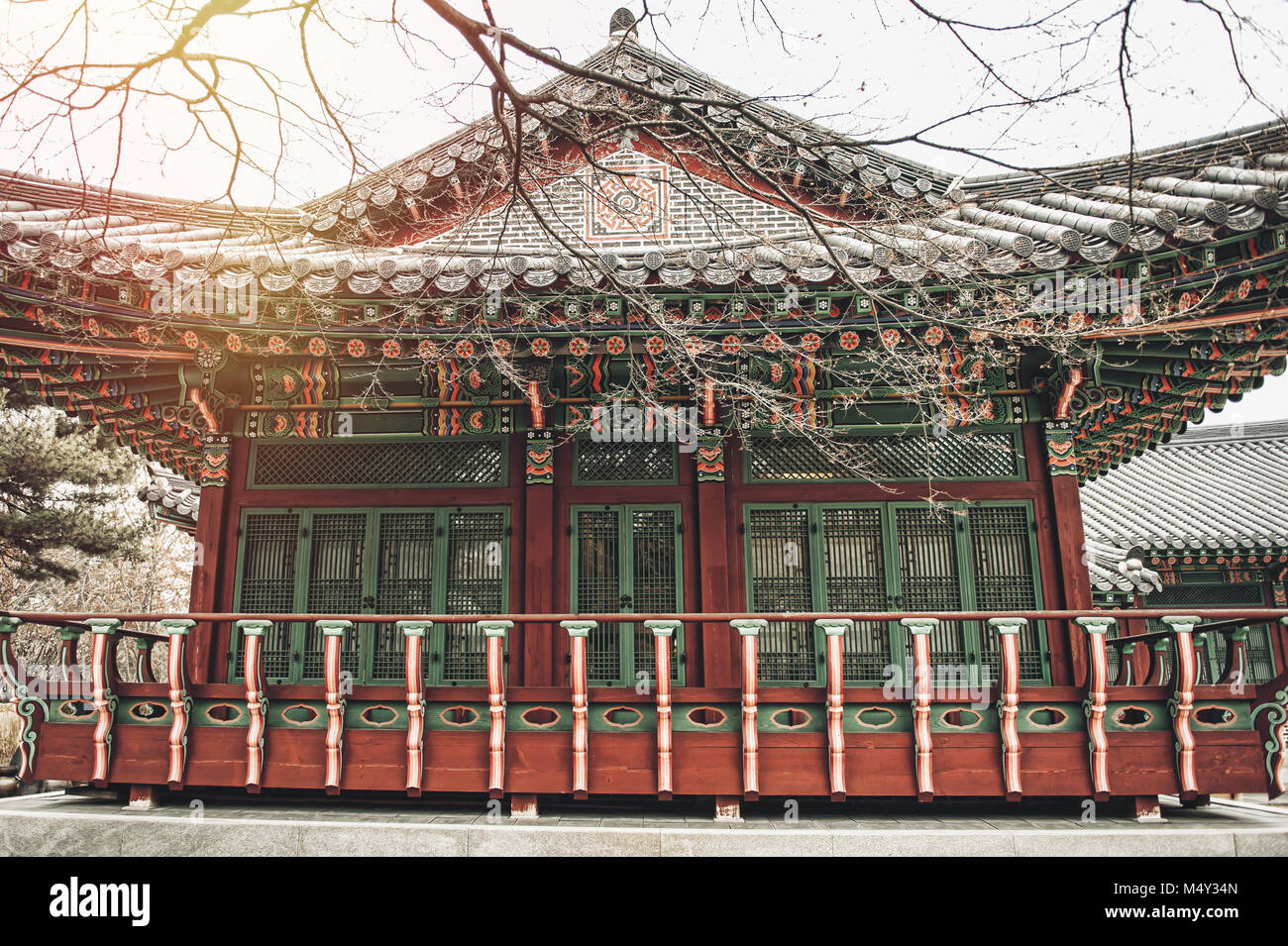 Casa Coreana tradizionale con sole invernale e alberi Foto Stock
