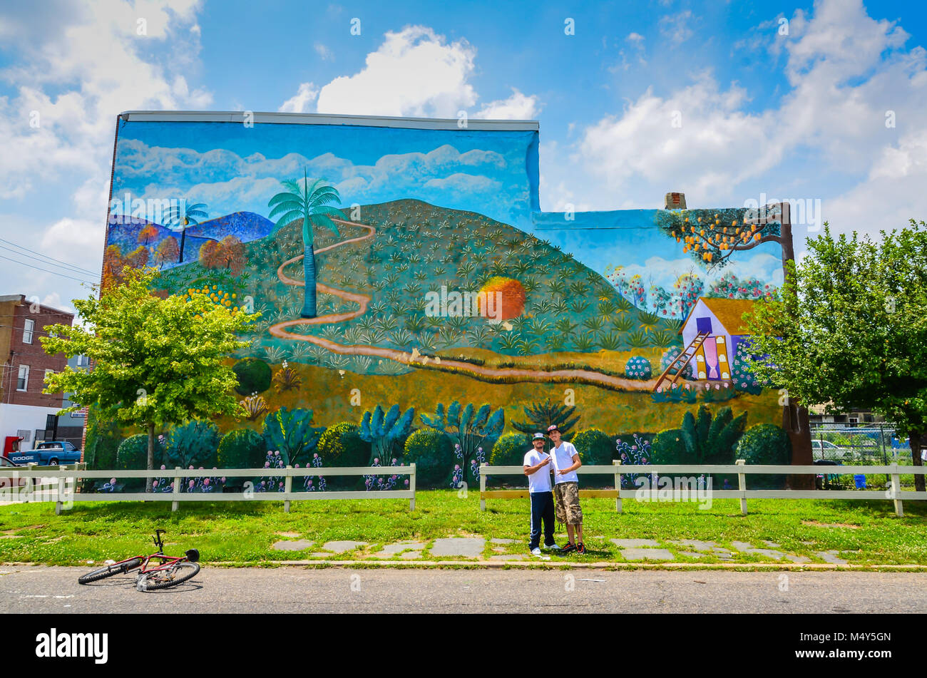 Due maschi Latino pongono di fronte Frito Bastien murale haitiani in Philadelphia, PA, Stati Uniti d'America. Foto Stock