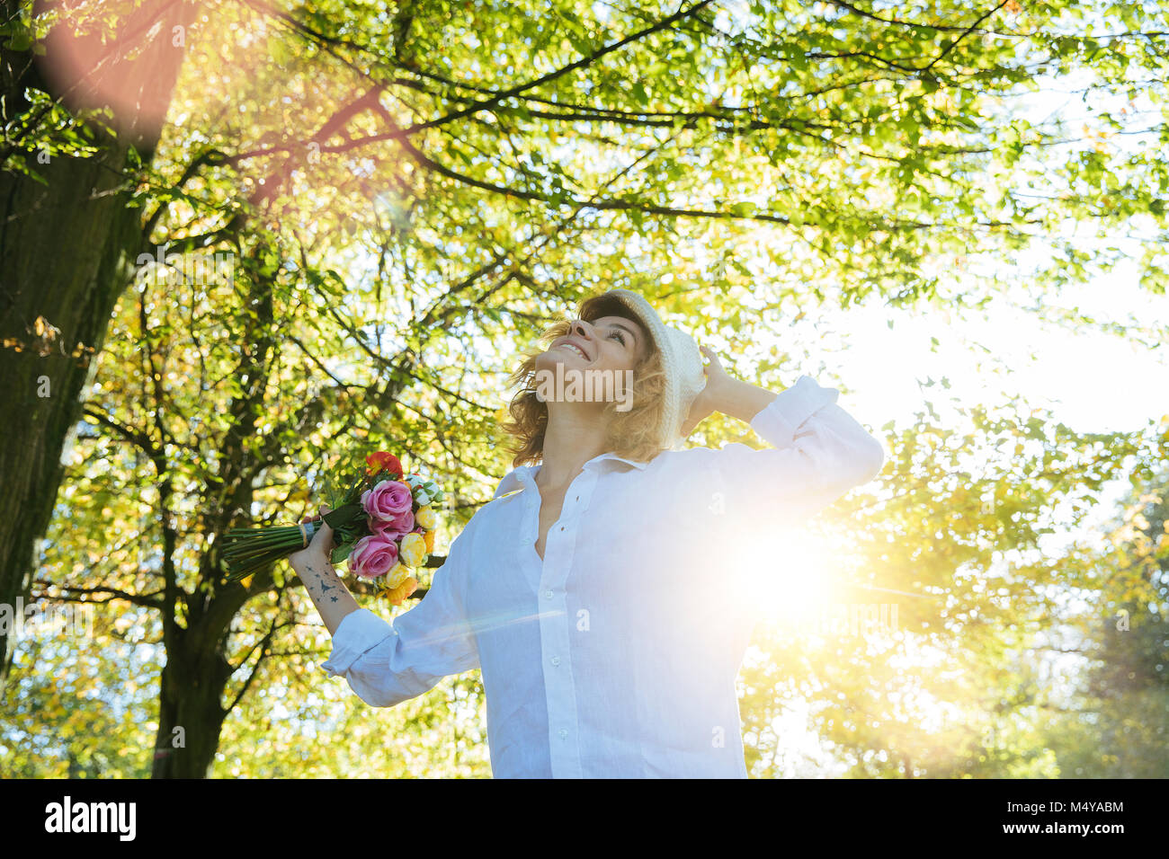 Godersi la natura. Giovane donna a braccia alzate godersi l'aria fresca nella foresta verde. Foto Stock
