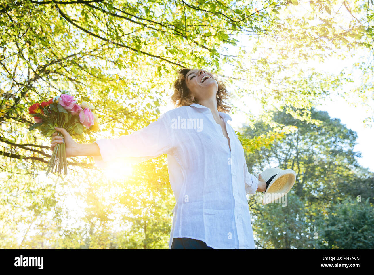Godersi la natura. Giovane donna a braccia alzate godersi l'aria fresca nella foresta verde. Foto Stock