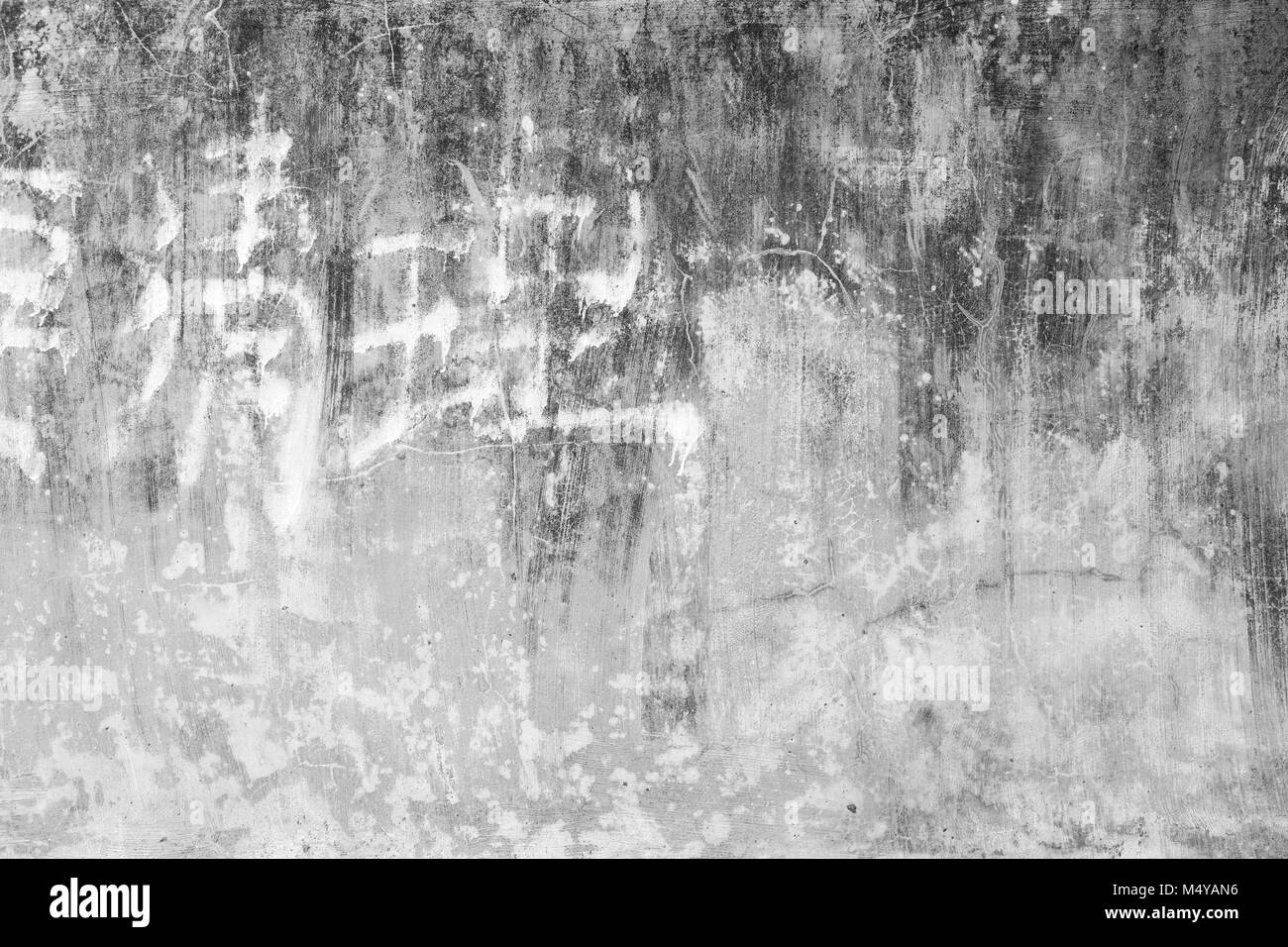 A spiovente e di età compresa tra la parete di calcestruzzo sfondo texture con alcuni sbiadito scrittura cinese in bianco e nero. Foto Stock