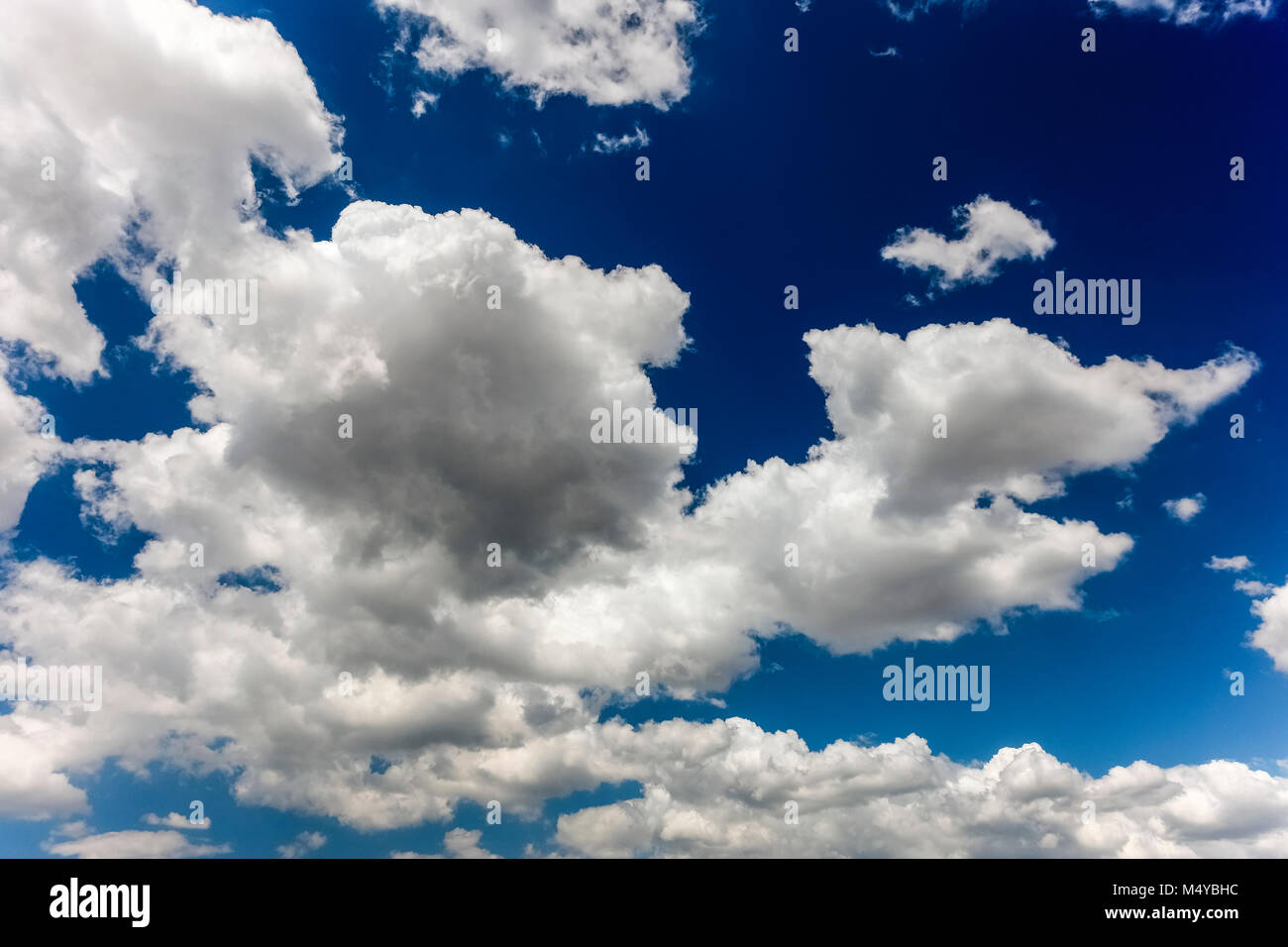 Grande colorato nuvole bianche in un profondo nuvoloso cielo blu sullo sfondo. Cloudscape, natura, meteorologia. Foto Stock