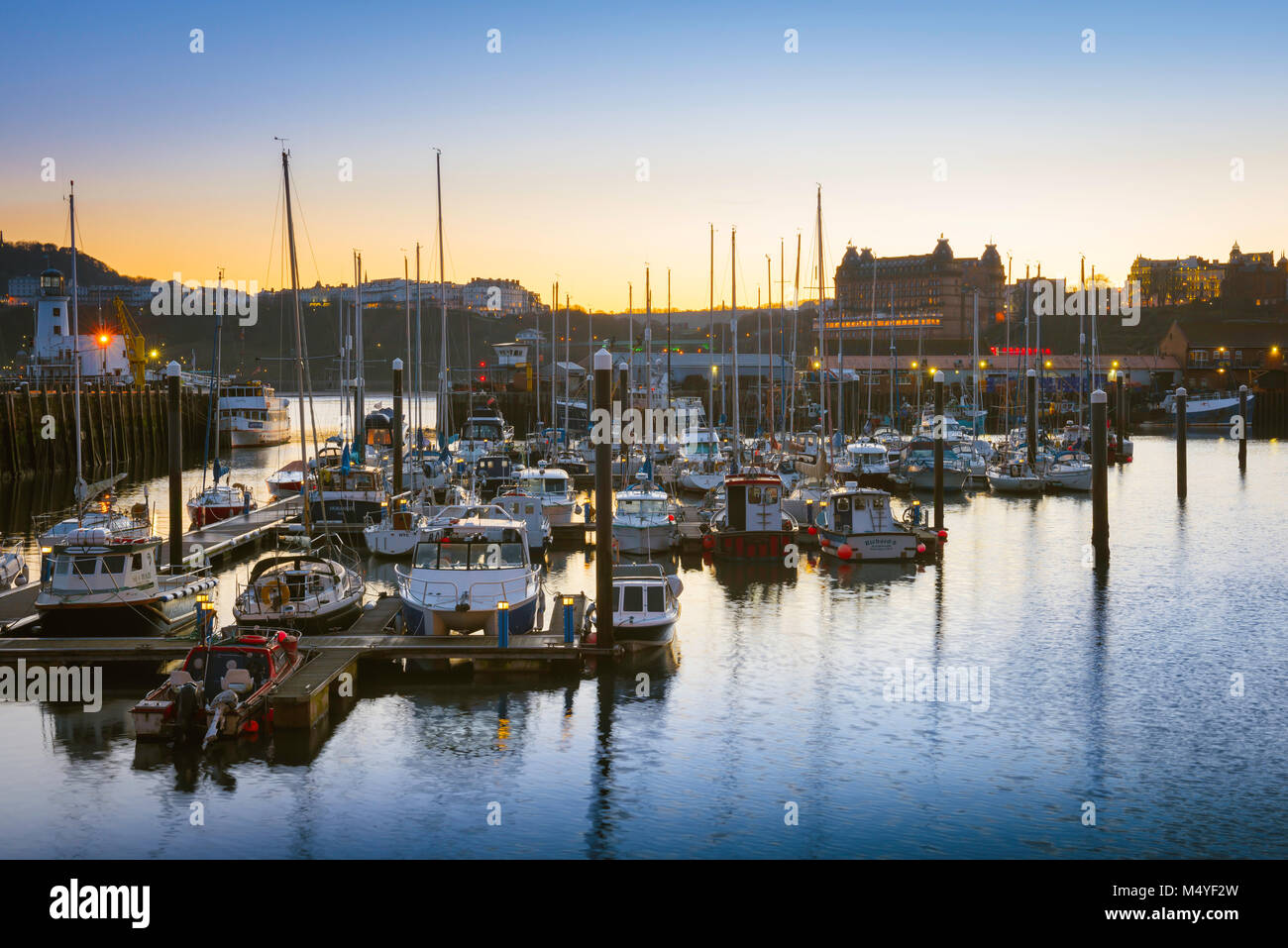 Scarborough Regno Unito, vista al tramonto della zona del porto e lo skyline di Scarborough visto dall'estremità nord di South Bay Beach, North Yorkshire. Foto Stock