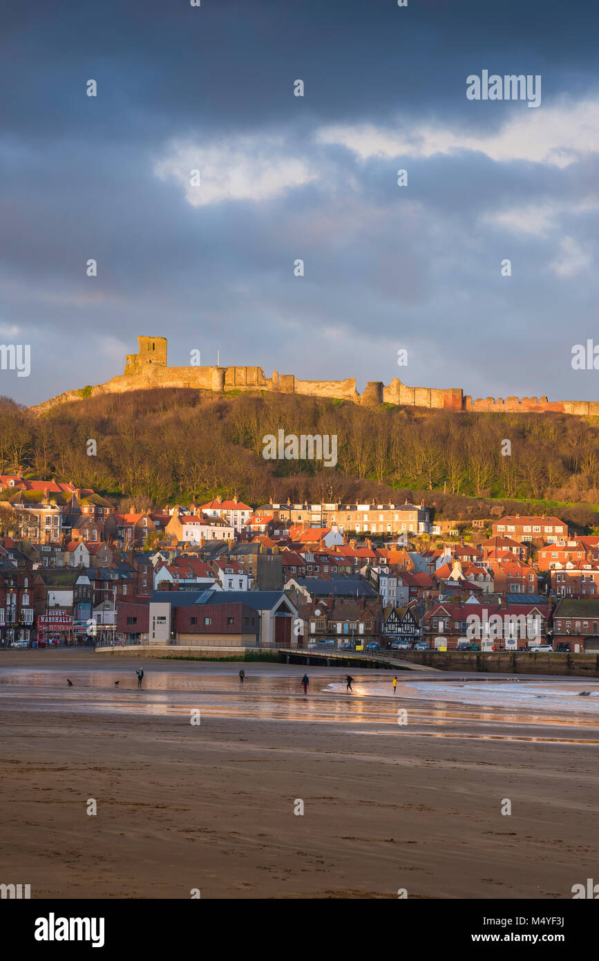 Scarborough Beach UK Winter, vista di South Bay Beach in Scarborough con il castello sopra la città illuminata da un tramonto, North Yorkshire, Inghilterra. Foto Stock