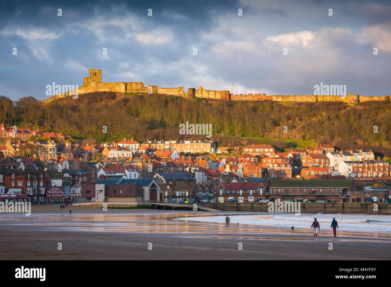 Scarborough Beach, vista fuori stagione di South Bay Beach a Scarborough con il castello sopra la città illuminata da un tramonto, Inghilterra, Regno Unito Foto Stock