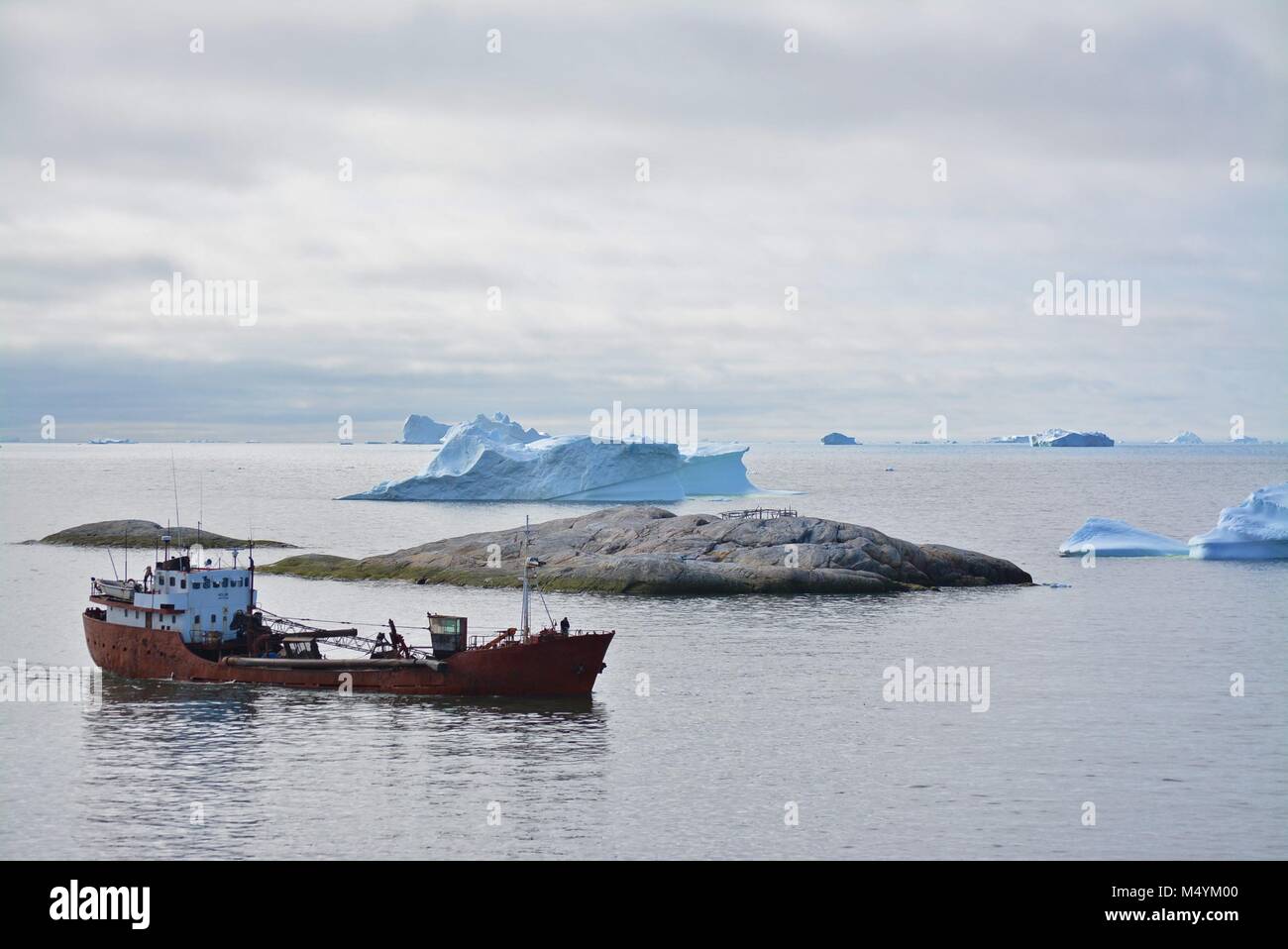 Lonely pesca in barca nella baia di Disko Ilulissat icebergs in luglio - iceberg - mare blu Foto Stock